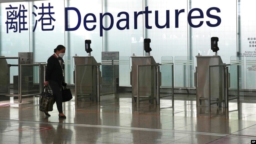 Lady walking past Hong Kong departure gates.