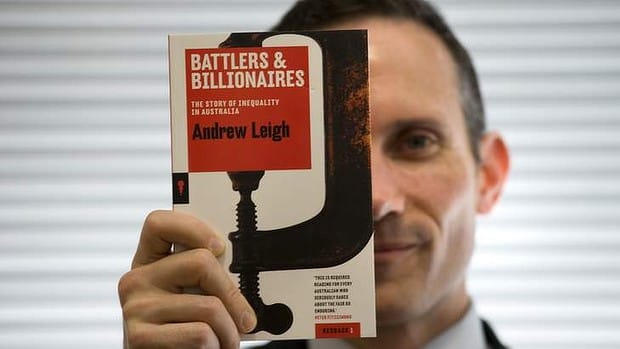 Andrew Leigh holding up his book, Battlers & Billion